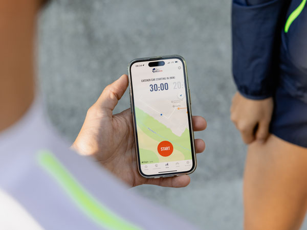 En deltagare h&aring;ller koll p&aring; telefonen och v&auml;ntar p&aring; att starten ska g&aring;.