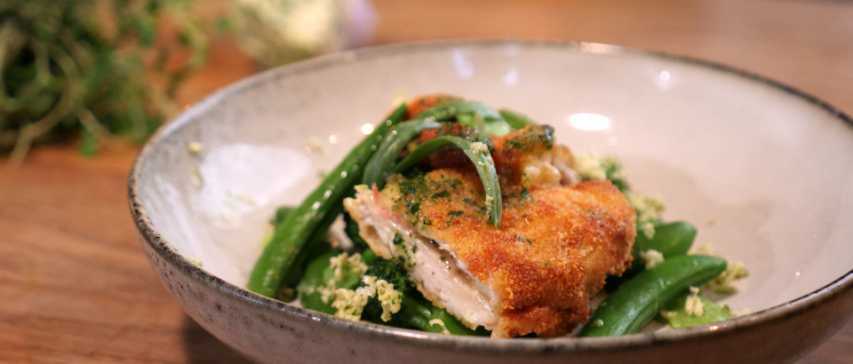 Amir Kheirmand lagar en krispig kycklingschnitzel med &ouml;rtsm&ouml;r och prim&ouml;rer